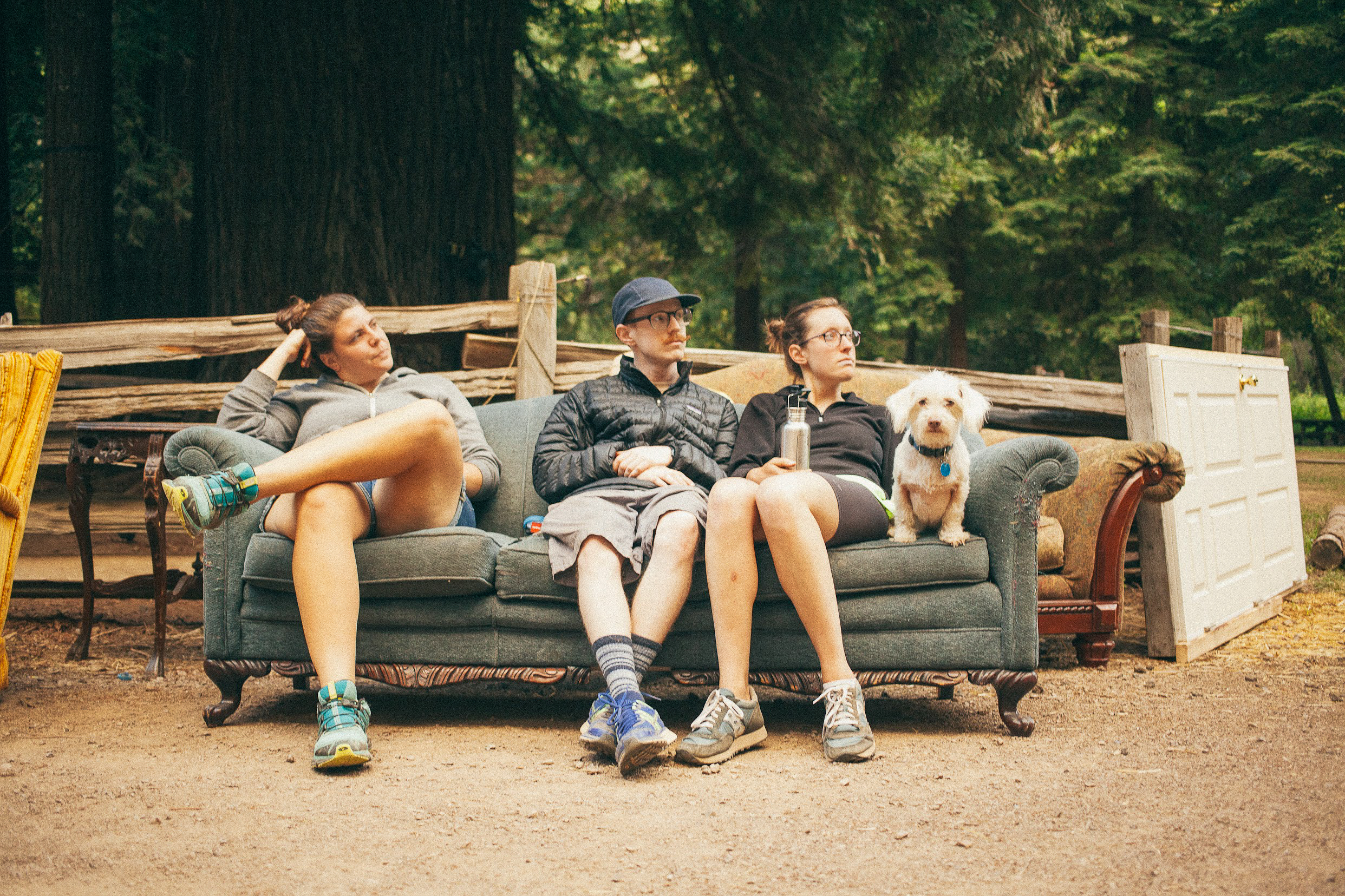 Campers relaxing on a couch in the redwoods at Camp Grounded